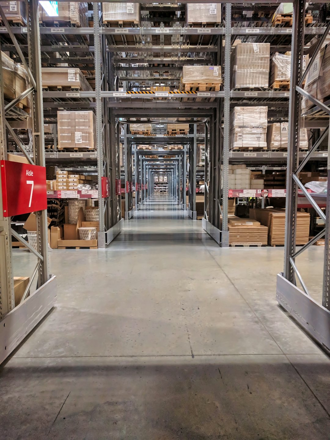 Rows of shelves stocked with merchandise in a large warehouse.